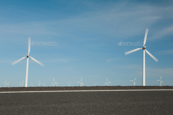 Wind turbines, tall white towers in the flat plains by a road near the Columbia River Gorge. - Stock Photo - Images