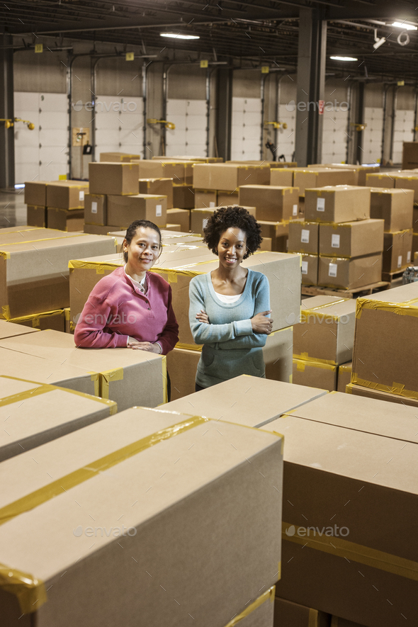 Team portrait of two African American female warehouse workers surrounded by products stored in - Stock Photo - Images