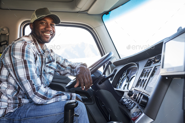 Black man truck driver in the cab of his commercial truck. - Stock Photo - Images