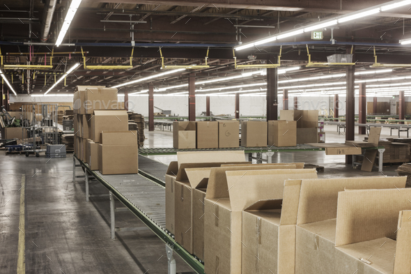 Interior view of a large distriubiton warehouse showing a mototized converyor system to move - Stock Photo - Images
