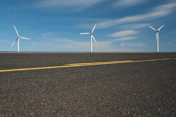 Three wind turbines on the horizon and a road runing through the plains near the Columbia River - Stock Photo - Images