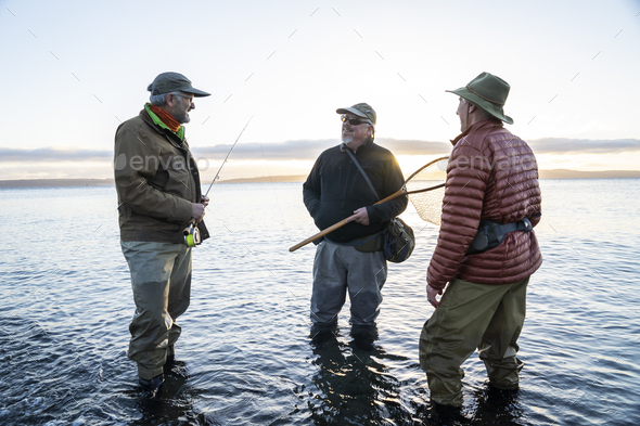 Two fly fisherman talk wtih their guide about new tecnhiques while fly fishing for searun coastal