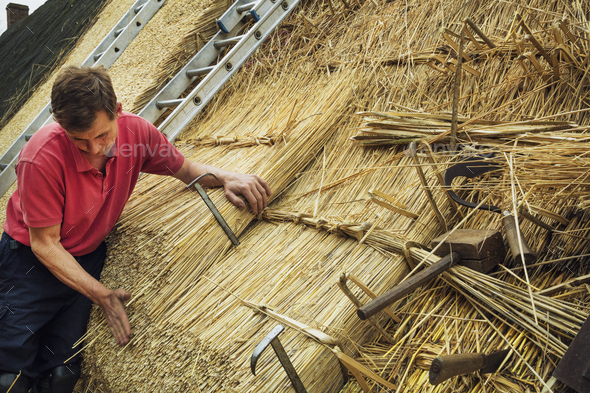 Man thatching a roof, thatching tools, including a wooden mallet, and shearing hooks.