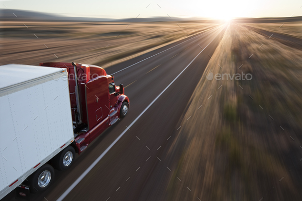 View from behind and above a commercial truck on the road at sunset on a highway in eastern - Stock Photo - Images