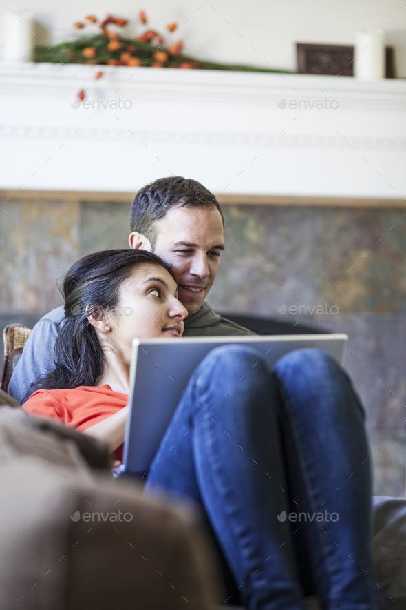 Friends Using Laptop On Sofa Mixed Race Typing Having Photo