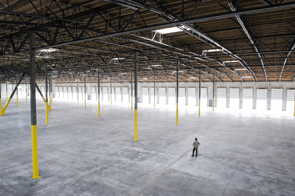 Owner checking out the new interior of a large empty warehouse space.