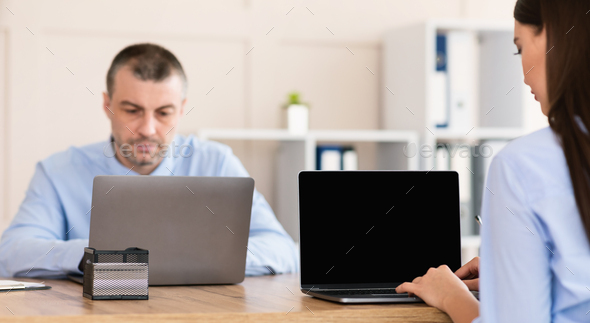 Businessman And Businesswoman Working On Computers Sitting At Workplace, Panorama - Stock Photo - Images