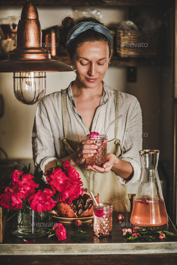 Young woman holding glass of rose homemade lemonade in hands - Stock Photo - Images
