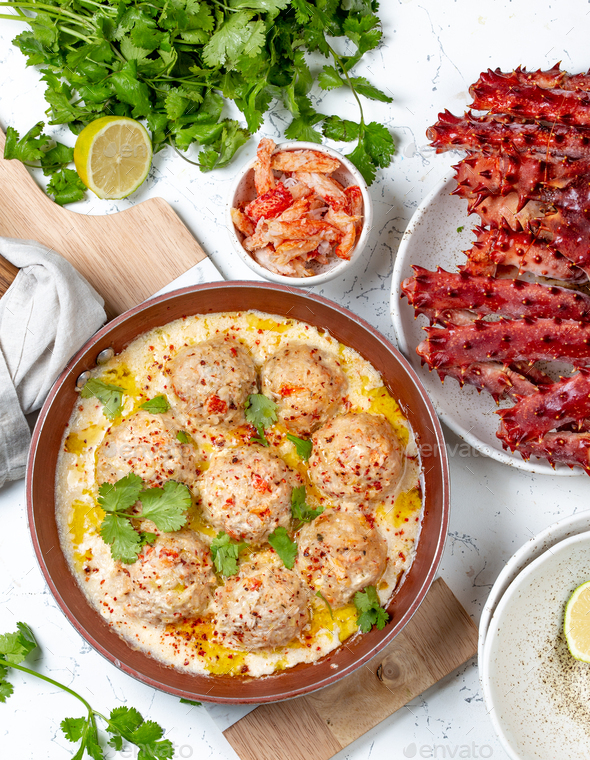meatballs in white creamy sauce in red pan - Stock Photo - Images