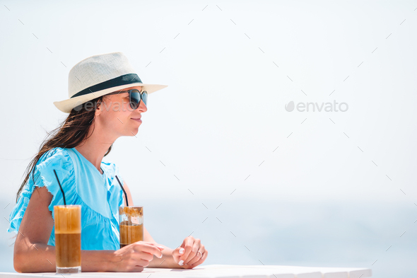 Young woman drinking cold coffee enjoying sea view - Stock Photo - Images