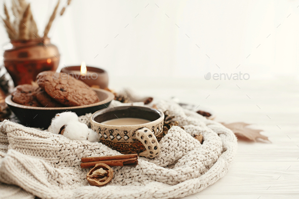 Hygge lifestyle, cozy autumn mood. Coffee cup, chocolate cookies, candle and fall leaves - Stock Photo - Images