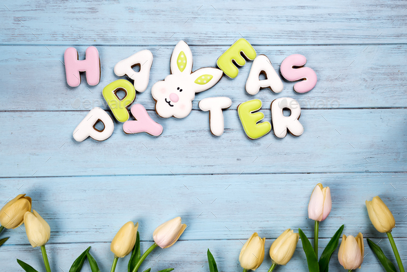 Happy Easter colorful lettering Happy Easter of ginger biscuits and cookies bunny on wooden blue - Stock Photo - Images