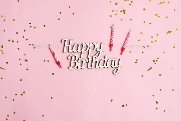 Festive backdrop from bright stars decoration, candles for cake and text  Happy Birthday on a pink Stock Photo by lyulkamazur