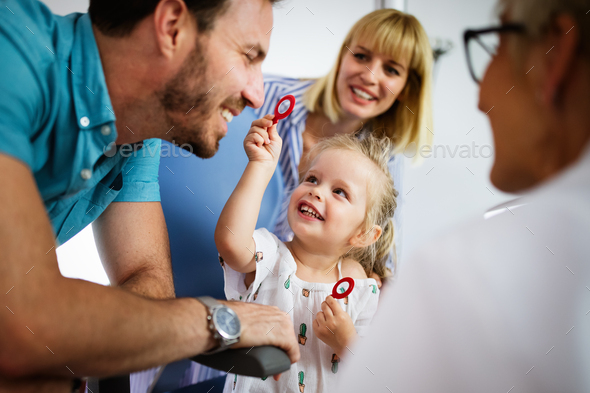Ophthalmologist is checking the eye vision of little cute girl in modern clinic - Stock Photo - Images