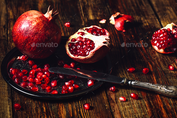 Whole and Opened Pomegranates on Metal Plate. - Stock Photo - Images