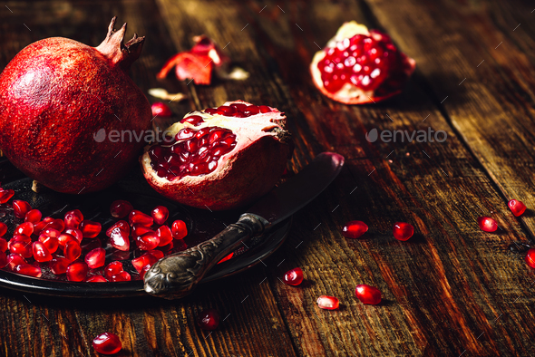 Whole and Opened Pomegranates on Plate - Stock Photo - Images