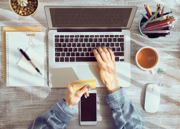 Online shopping concept. Unrecognizable woman drinking tea and looking at laptop - Stock Photo - Images
