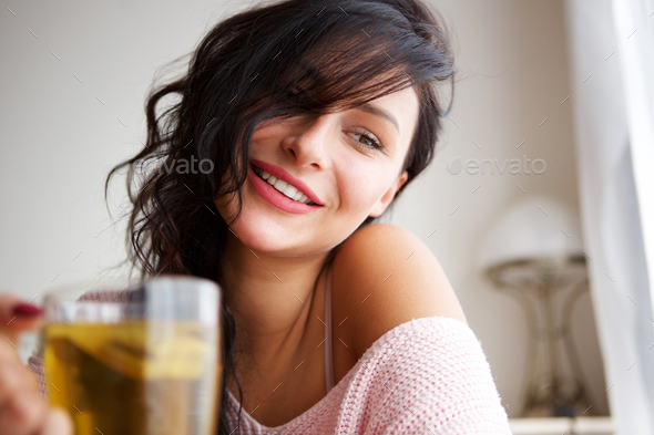 happy woman inside cozy apartment with hot drink
