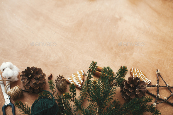 Stylish rustic christmas gift box, wrapping paper, wooden reindeer, pine  branches and cones, gingerbread cookies on rural wooden table. Merry  Christmas. Seasons greeting card, Stock image