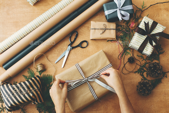 Merry Christmas, flat lay. Hands wrapping stylish christmas gift box - Stock Photo - Images