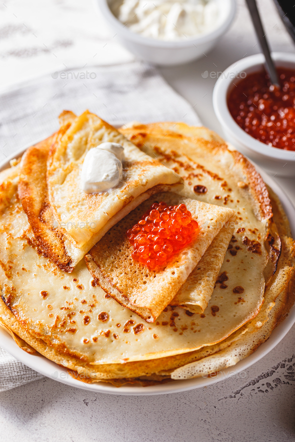 Stack of russian pancakes blini with red caviar, fresh sour cream - Stock Photo - Images