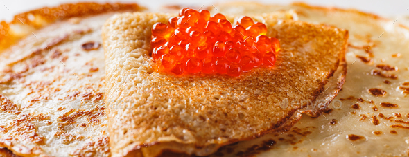Stack of russian pancakes blini with red caviar, fresh sour cream - Stock Photo - Images