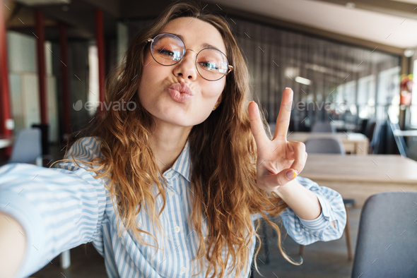 Image Of Happy Woman Gesturing Peace Sign And Taking Selfie Photo Stock