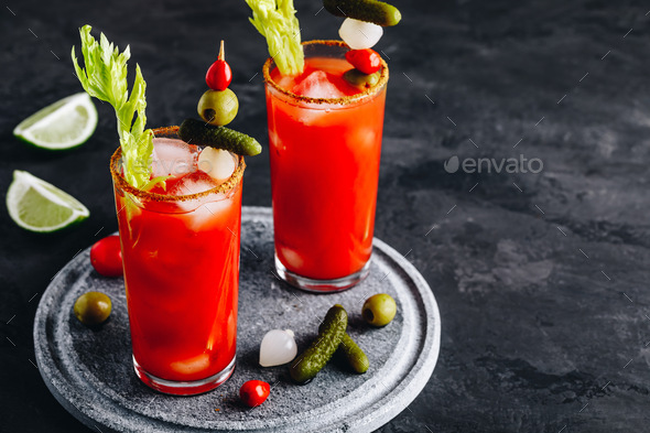 bloody mary cocktail in glasses garnished with lime and celery isolated on  white Stock Photo by LightFieldStudios