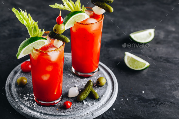 Bloody Mary Cocktail in glasses with garnishes. Stock Photo by nblxer