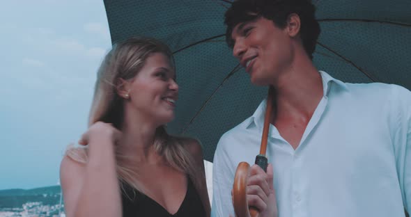 Couple holding umbrella and smiling alt