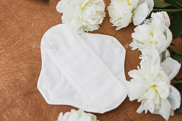 Reusable eco natural pad for menstrual days with peony flowers. White feminine washable