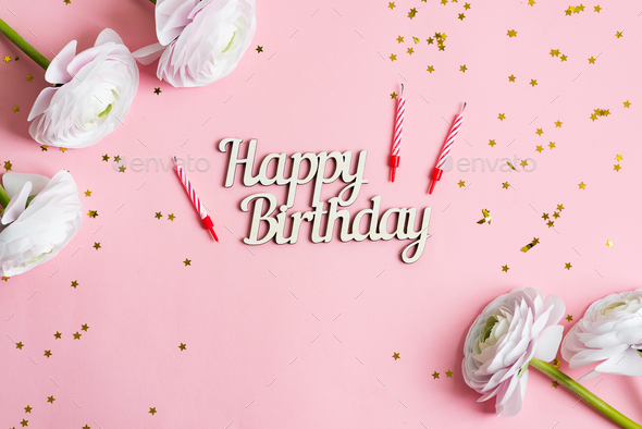 Festive backdrop from bright stars decoration, candles for cake and text Happy Birthday , ranunculus - Stock Photo - Images