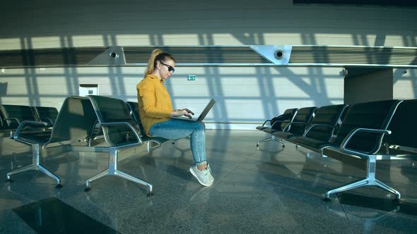 Airport Waiting Hall with a Lady Working on a Computer alt