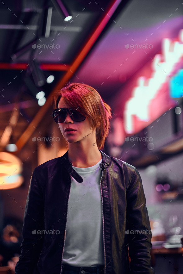 Stylish redhead girl standing in the night on the street. Illuminated signboards, neon, lights. - Stock Photo - Images