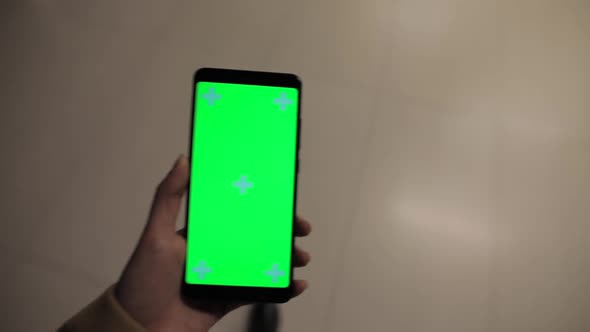 POV, Female Hand Holding Smartphone Green Screen in a Mall alt