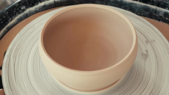 Сlay cup spinning on a potter's wheel. Сlay plate plate spins on a potter's wheel.