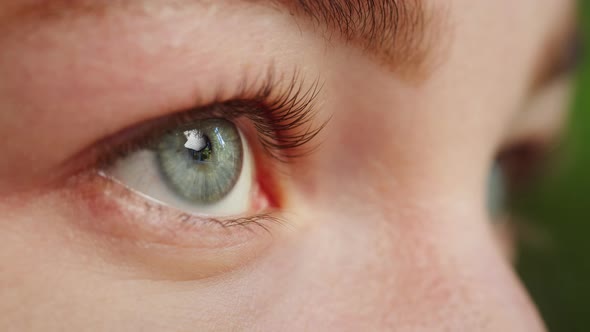 Closeup of a Light Blue Eye Blinking Opening and Closing Eyes Painted Lashes alt