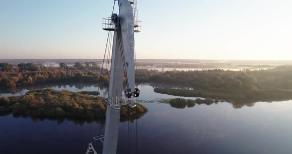 Boom of an Idle Port Crane on the Background of the River at Dawn alt