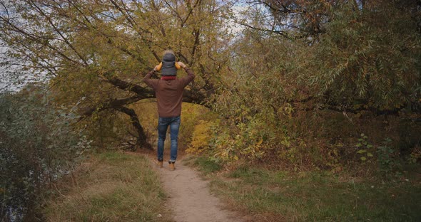 Man Is Spending Time with His Child Son at Weekend, Walking Together in Park or Forest, Picturesque alt