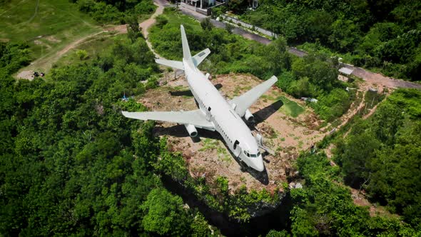 White Airplane on Brown Earth in Green Tropical Bushes alt