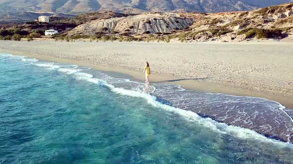 Aerial Drone Footage of a Girl Walking Along a Lonely Beach