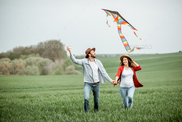 Lovely couple with kite on the greenfield - Stock Photo - Images