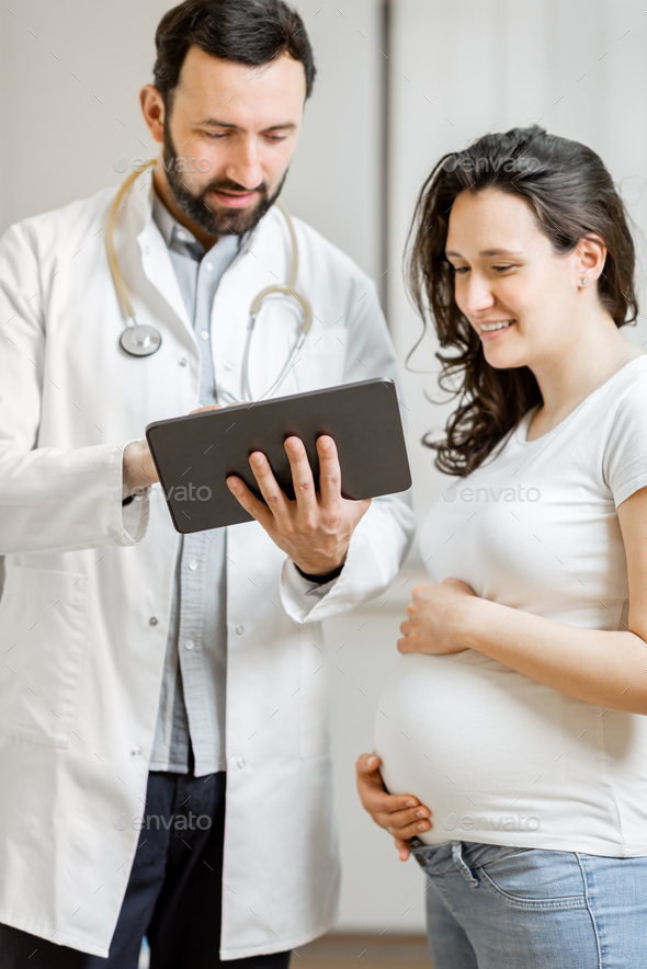 Doctor with pregnant woman during a medical consultation - Stock Photo - Images