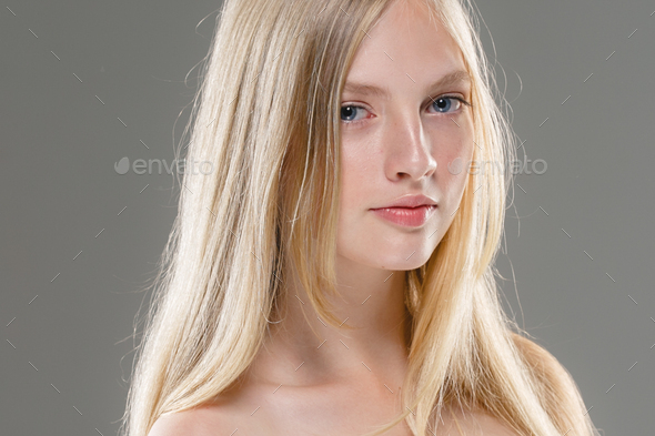 Beautiful Woman Face Portrait Beauty Skin Care Concept with long blonde hair over gray background - Stock Photo - Images