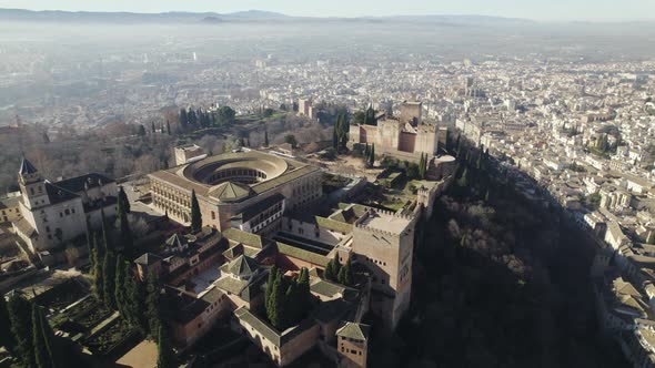 Panoramic view of Alhambra with foggy landscape in background, Granada in Spain. Aerial drone descen