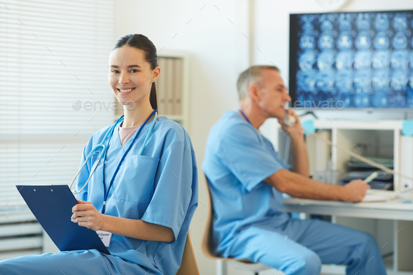 Smiling Female Nurse Holding Clipboard in Hospital - Stock Photo - Images