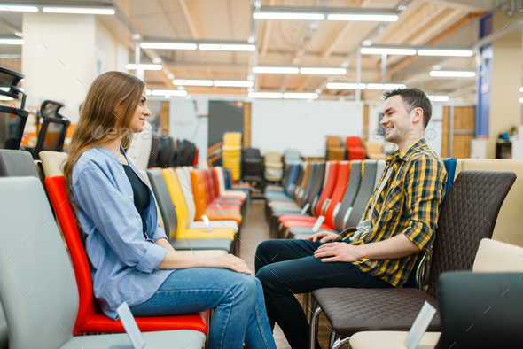 Couple choosing chairs in furniture store showroom - Stock Photo - Images