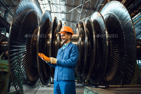 Worker checks turbine impeller vanes on factory - Stock Photo - Images