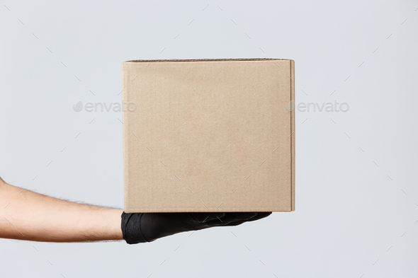 Contactless delivering, covid-19 and shopping concept. Image of courier hand in rubber gloves - Stock Photo - Images