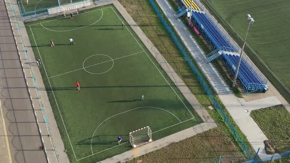 Top view of a sports football field with players playing football